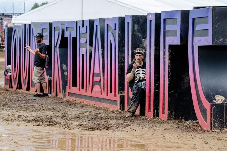 Fans by the mud-laden LTL sign on Day 4 of the Louder Than Life Festival on September 29, 2024 at the Kentucky Exposition Center (29).jpg