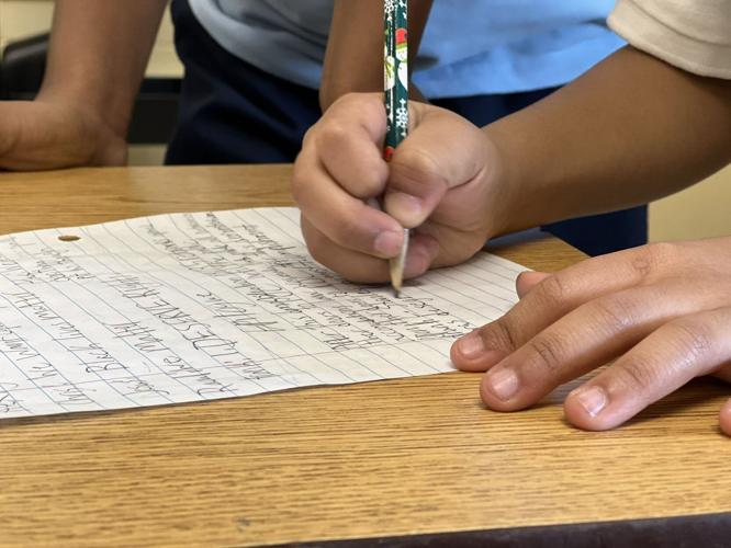 Student writes notes during Black History Month project