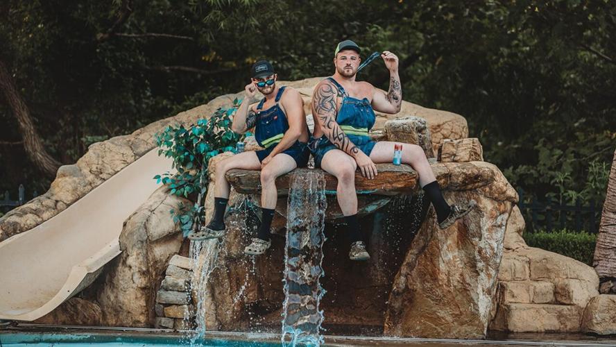 Skyler Ipock and Aaron Brothers sit on fountain