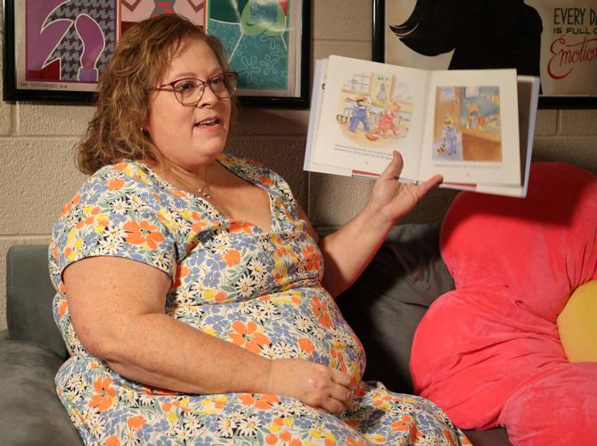 Lisa Overstreet reads a children's book inside her office
