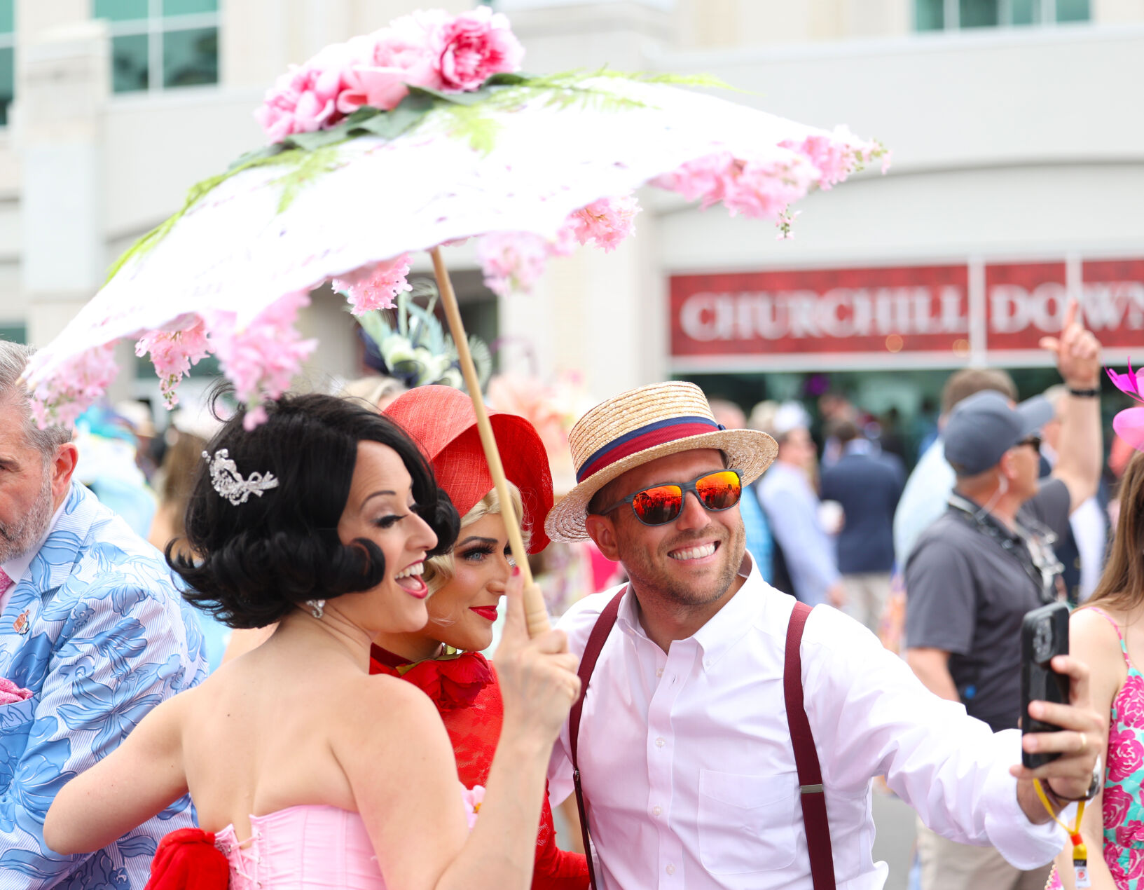 Group holding umbrella takes selfie.JPG