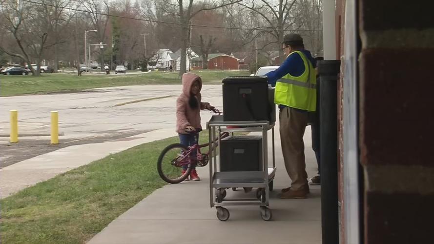 JCPS student on bike picking up laptop.jpg