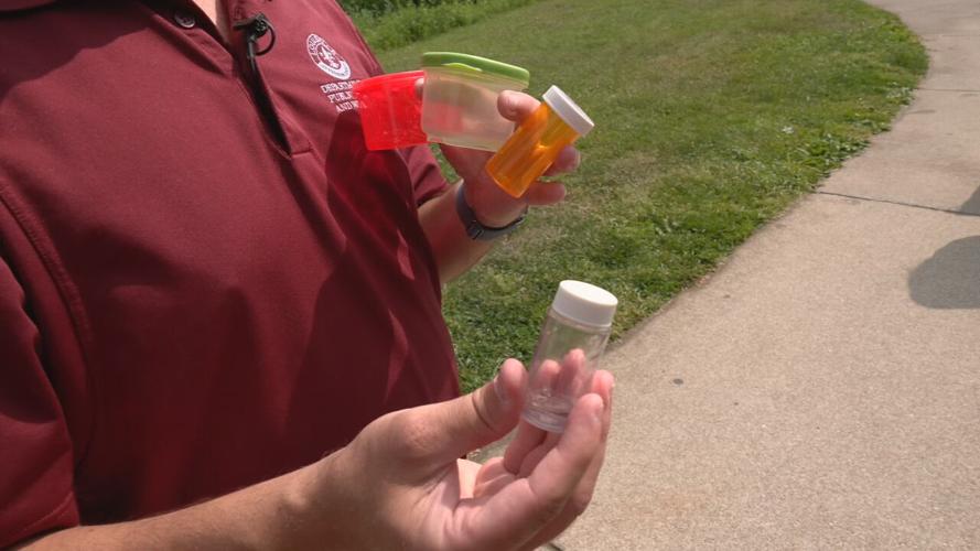 A representative of Louisville Metro Health and Wellness shows a tick that's been collected