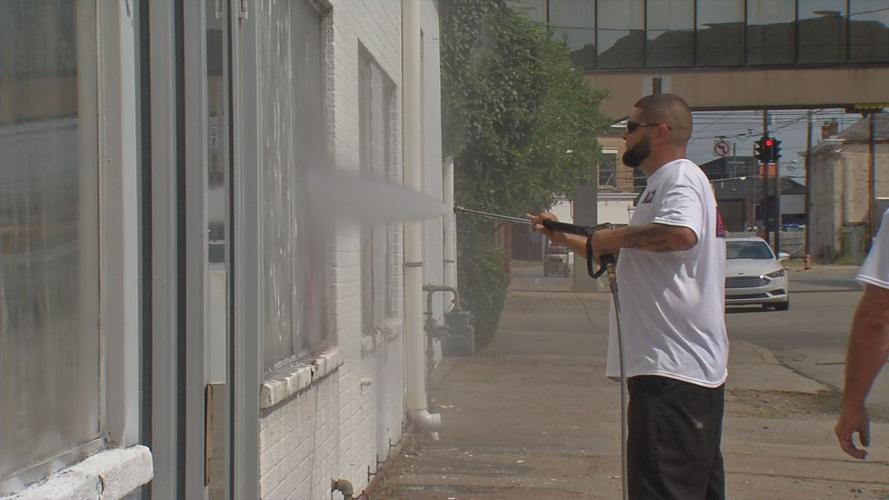 Employee of Veterans ProWash volunteers to clean graffiti from Home of the Innocents building (Aug. 14, 2019)