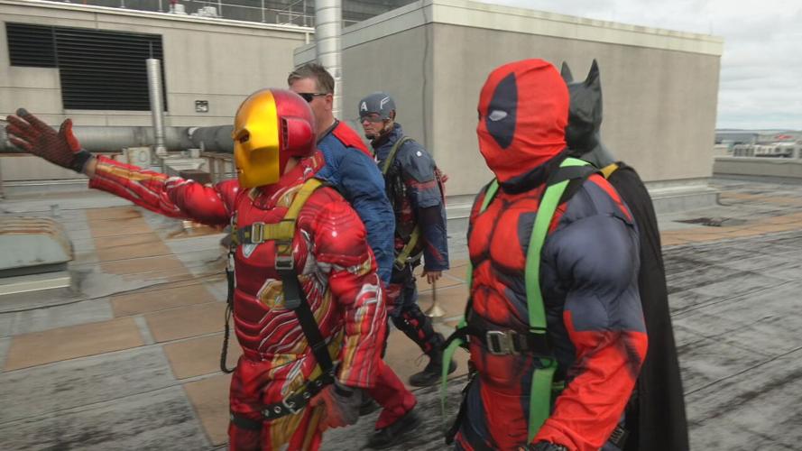 Window washers prepare to rappel from Norton Children's Hospital dressed as superheroes