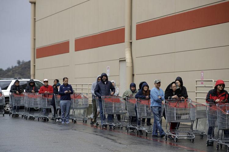 Shoppers wait to enter a Costco warehouse Saturday, March 14, 2020, in Santa Clarita, Calif