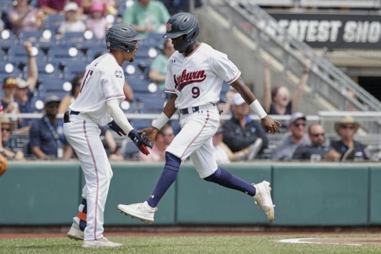 Auburn's Ryan Bliss (9) is greeted by Auburn's Will Holland