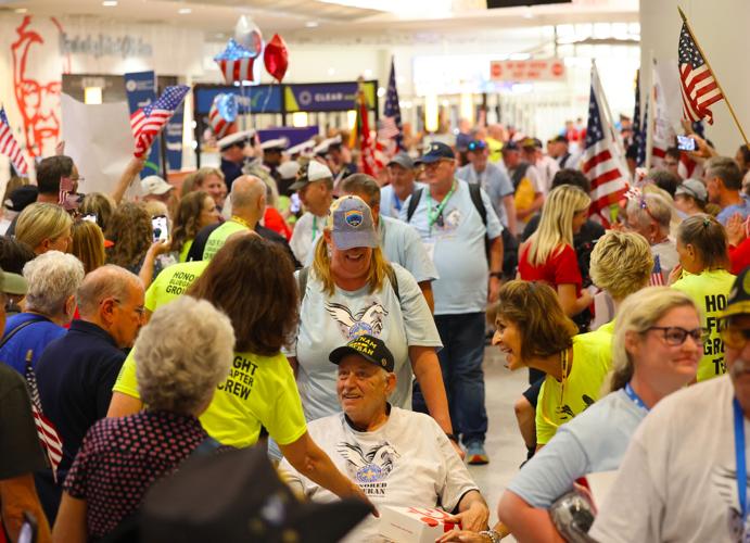 Veteran is pushed through crowd at Honor Flight Return Home.JPG
