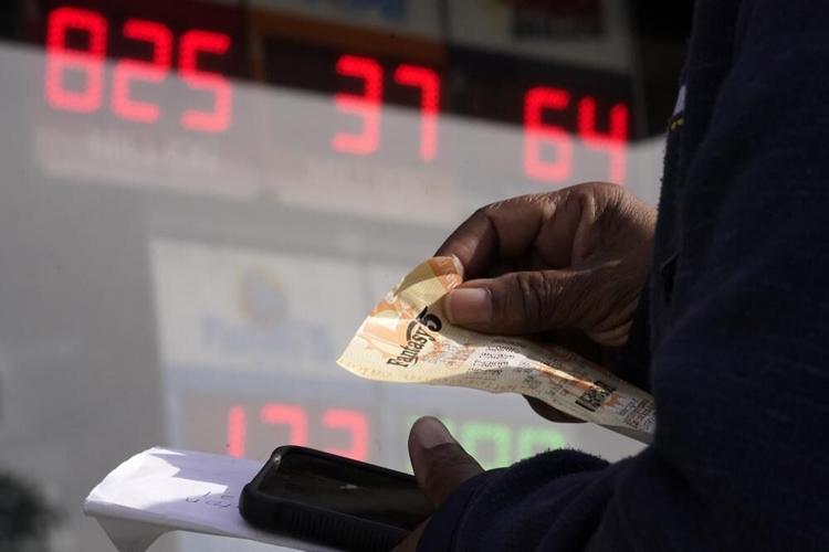 A customer holds a lottery ticket.jpeg