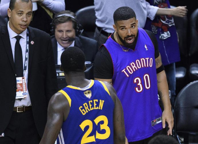 Drake says something to Golden State Warriors forward Draymond Green
