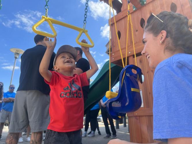 Jaxon Gass plays on swingset