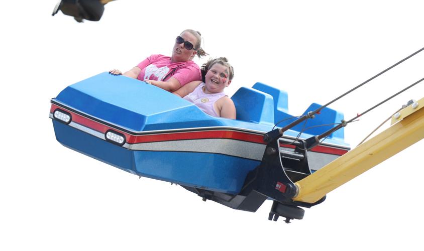 People ride on an amusement ride at the Midway