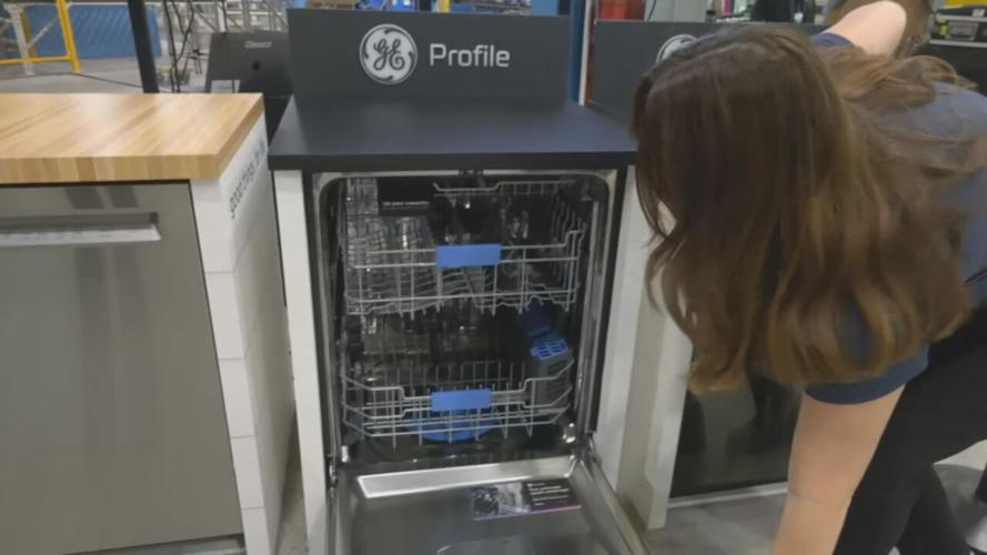 An employee at GE Appliances shows off the plant's new dishwashers