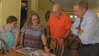 Breanna Coleman, with parents Lisa and Dwight Coleman, going over baby books.