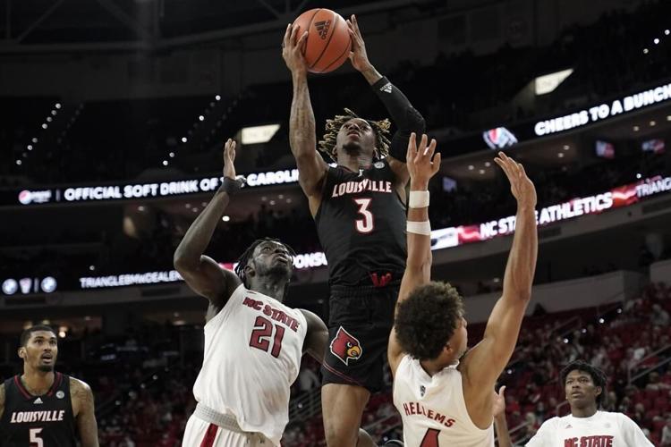 Louisville guard El Ellis shoots between North Carolina State defenders.jpeg