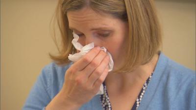 Woman blowing her nose