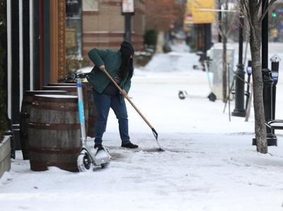 Woman shovels snow in downtown Louisville.JPG