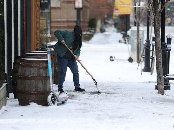 Woman shovels snow in downtown Louisville.JPG