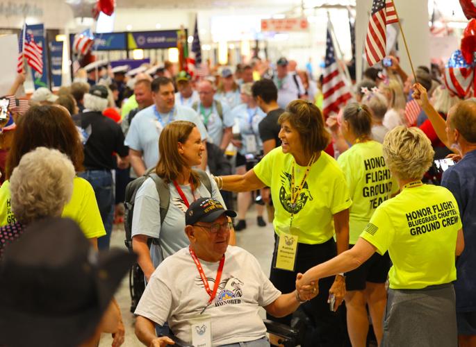 Veteran shakes hand of volunteer at Honor Flight Return Home.JPG