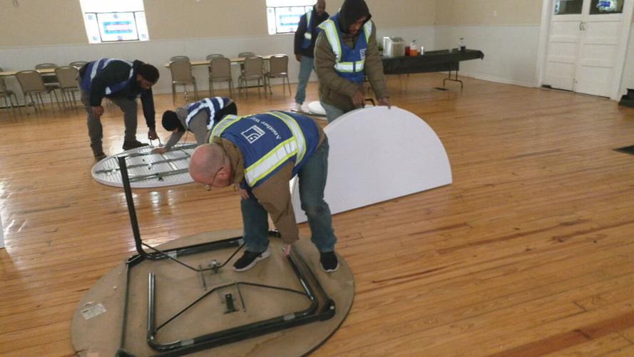 Volunteers with Goodwill's Another Way program work to set up an emergency pop-up shelter in Louisville's California neighborhood Monday morning.