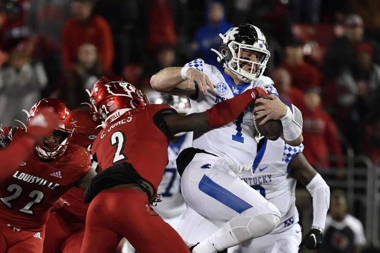 Kentucky quarterback Will Levis is grabbed by Louisville defensive back Chandler Jones