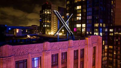 Grok Deepfakes - Workers install lighting on X sign in San Francisco