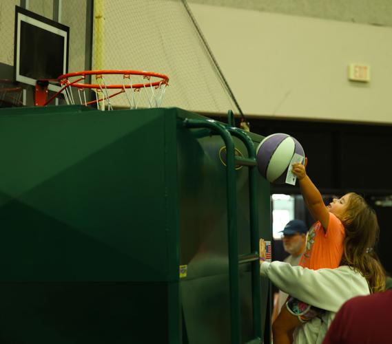 Girl reaches for basketball goal at state fair.JPG