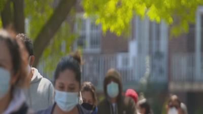 People wearing masks walking outdoors