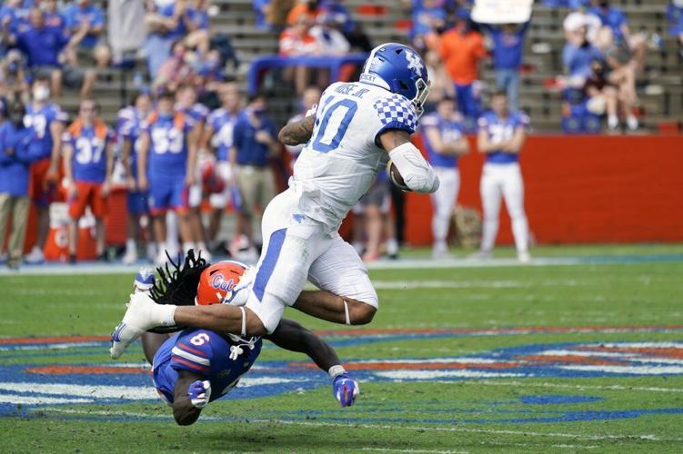 Kentucky running back Asim Rose Jr., right, tries to leap over Florida defensive back Shawn Davis