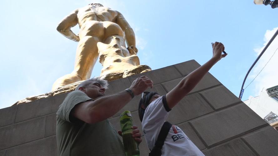 Couple poses under David statue outside 21C hotel in downtown Louisville