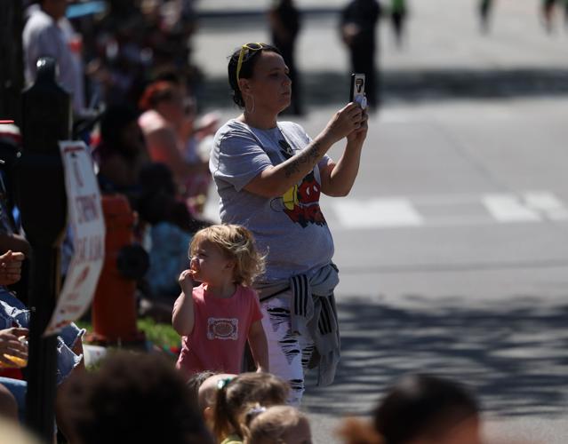 Woman takes cell phone video at Pegasus Parade