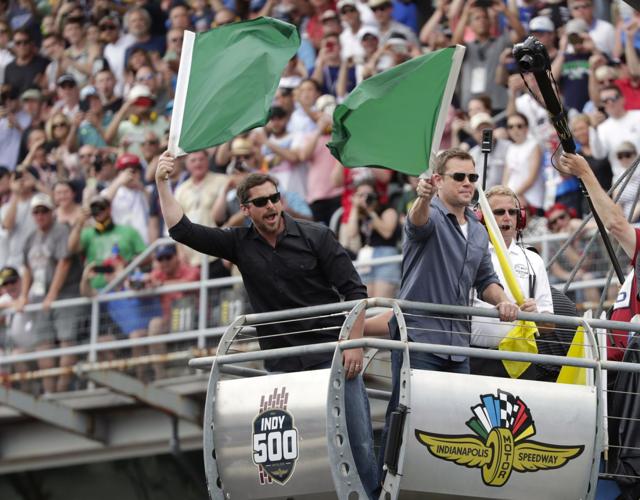 Matt Damon and Christian Bale wave green flags