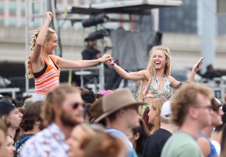 Two girls grasp hands at Forecastle 2022.JPG