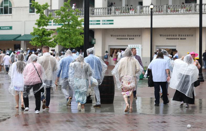 People wearing ponchos walk at Churchill Downs.JPG