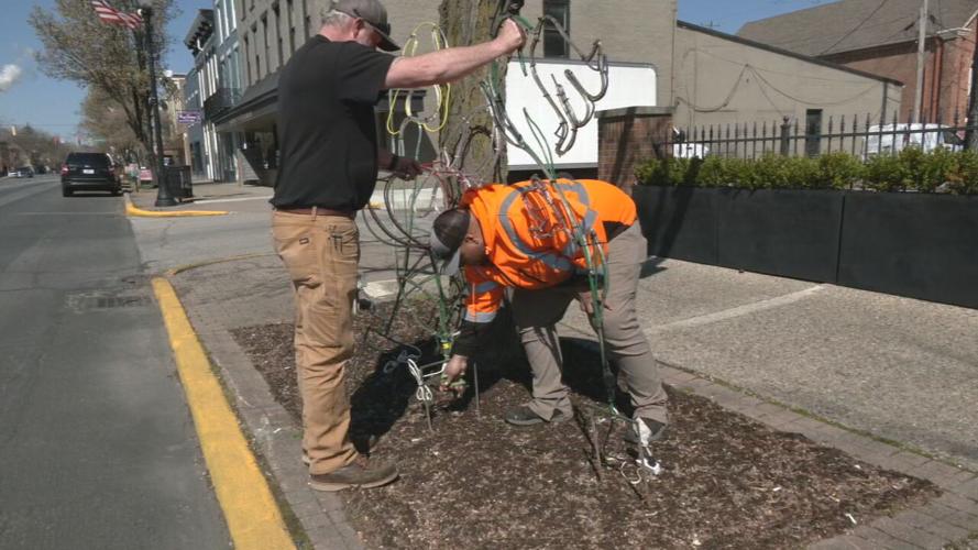 Billy Applegate and Lionel Smith place lighted displays of spring flowers around Madison