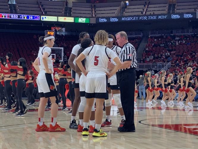 Members of the U of L women's basketball team talk with an official