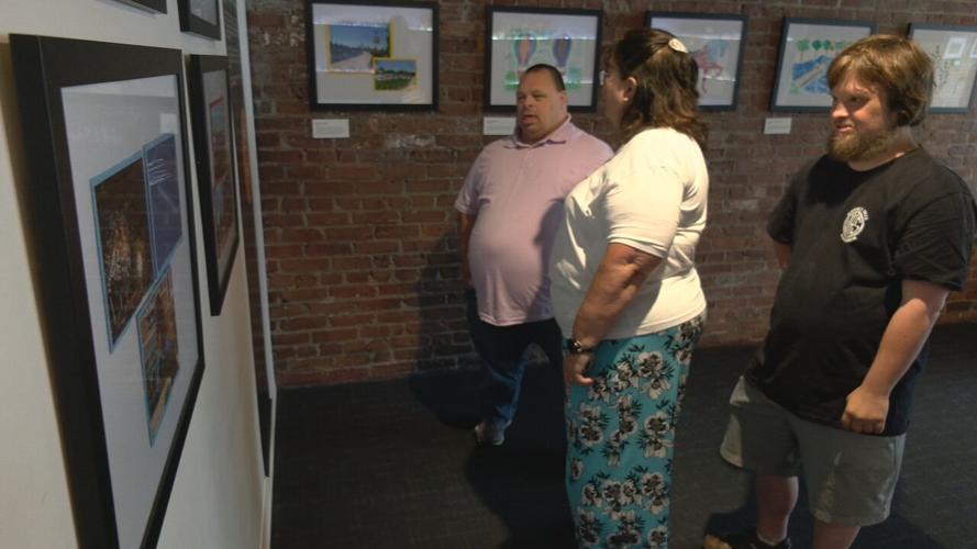 Artists review a Frazier History Museum exhibit showcasing work by artists with Down Syndrome