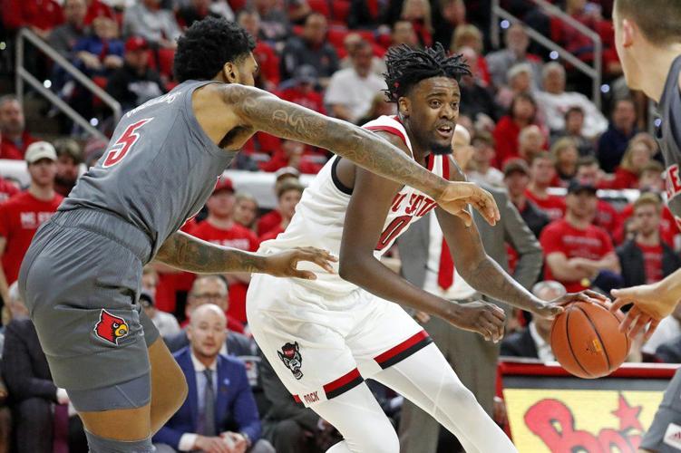North Carolina State's DJ Funderburk (0) drives the ball as Louisville's Malik Williams (5) defends