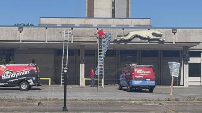 Crews removing sign from former site of Greyhound bus station in downtown Louisville