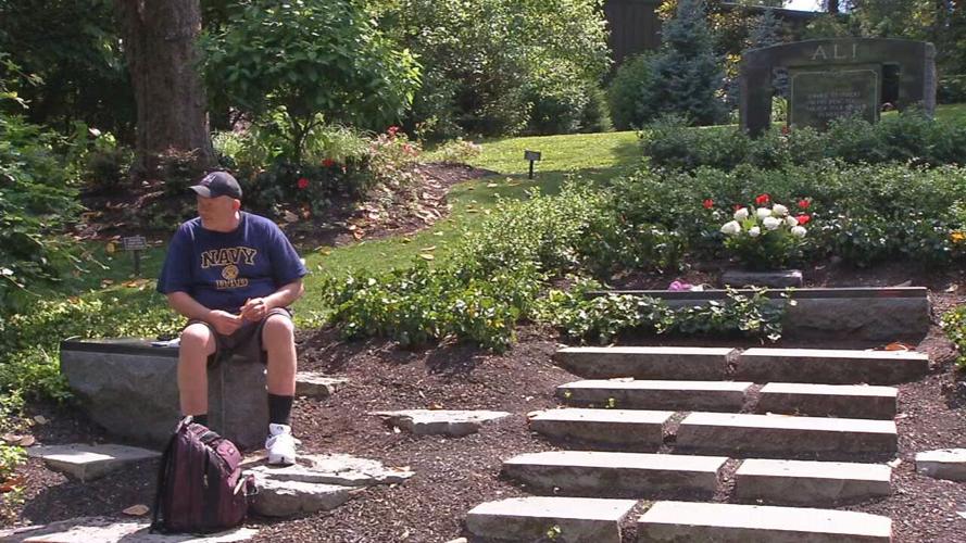 A man visits Muhammad Ali's grave in Cave Hill Cemetery