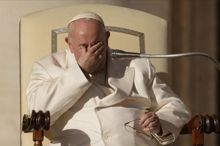 Pope Francis touches his face