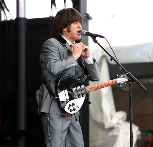 Performer sings into microphone at Abbey Road on the River.JPG