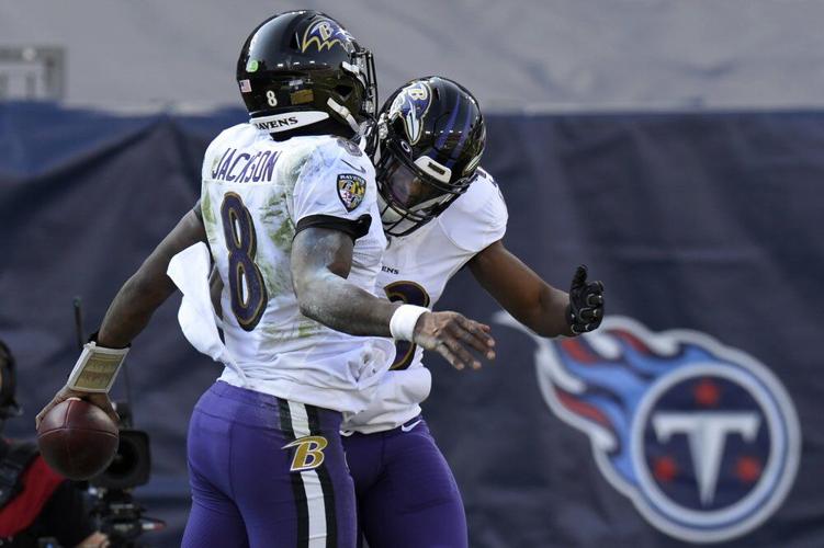 Baltimore Ravens quarterback Lamar Jackson (8) celebrates with running back Justice Hill