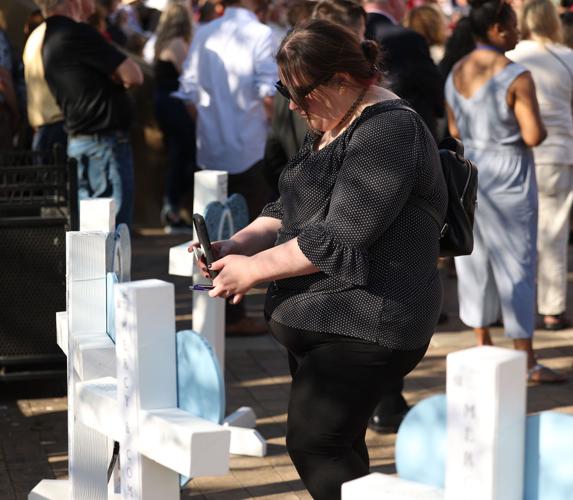Person takes photos of crosses of victims.JPG