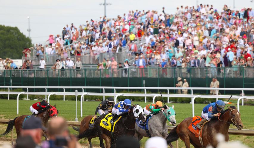 Horses run as fans cheer at infield stands.JPG