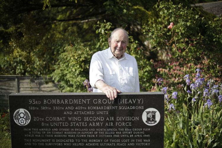 David Woodrow poses for photographs next to the memorial