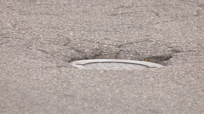 Exposed metal plate on N 20th St in Louisville surrounded by potholes and cracks Thursday, October 14, 2021.PNG