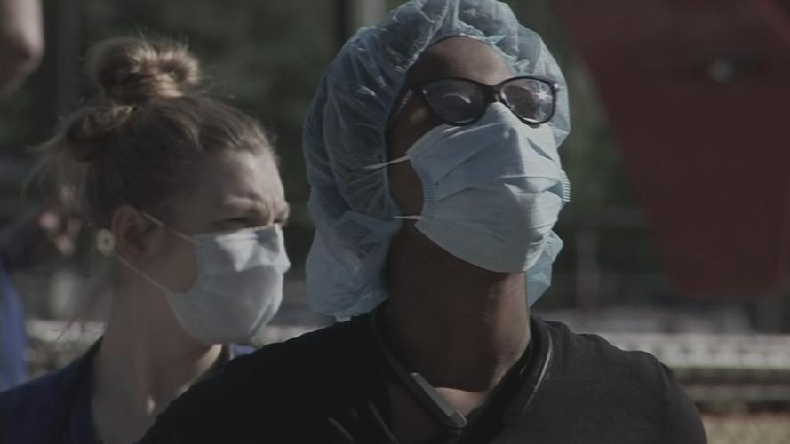 Health care workers look up at flyover