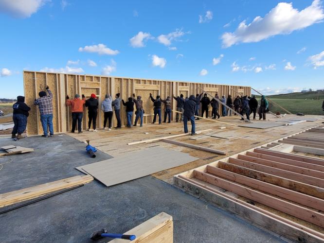 Community members help Wooldridge family raise first wall of new home