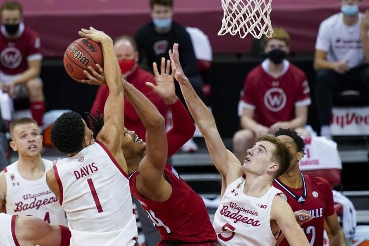 Wisconsin's Jonathan Davis (1) blocks a shot by Louisville's Jae'Lyn Withers